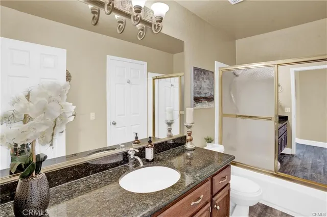 a bathroom with a granite countertop sink a mirror a and a shower