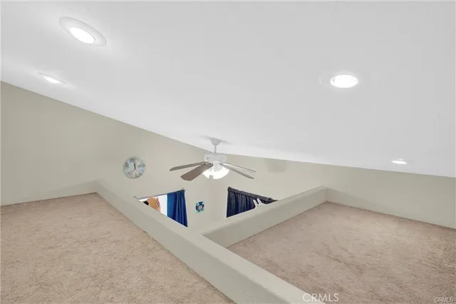 an empty room with windows and ceiling fan