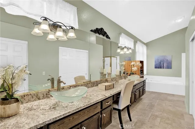 a bathroom with a granite countertop sink a mirror and a bathtub
