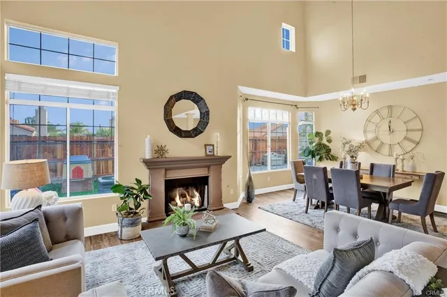 a living room with furniture a fireplace and a floor to ceiling window