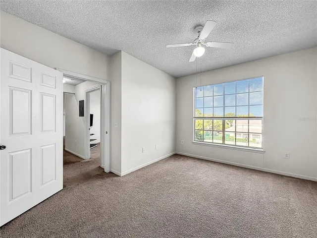 a view of a tennis ground with large trees