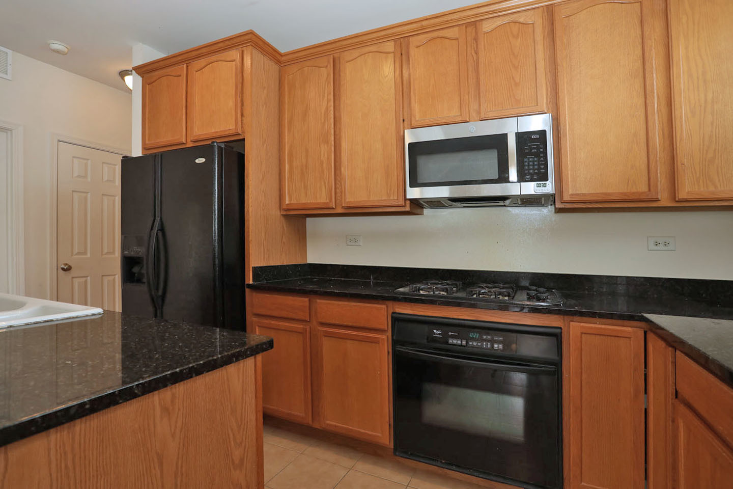 1359 Scarboro Road Schaumburg, IL 60193 - Photo 11 of 21 a kitchen with stainless steel appliances granite countertop a stove microwave and refrigerator