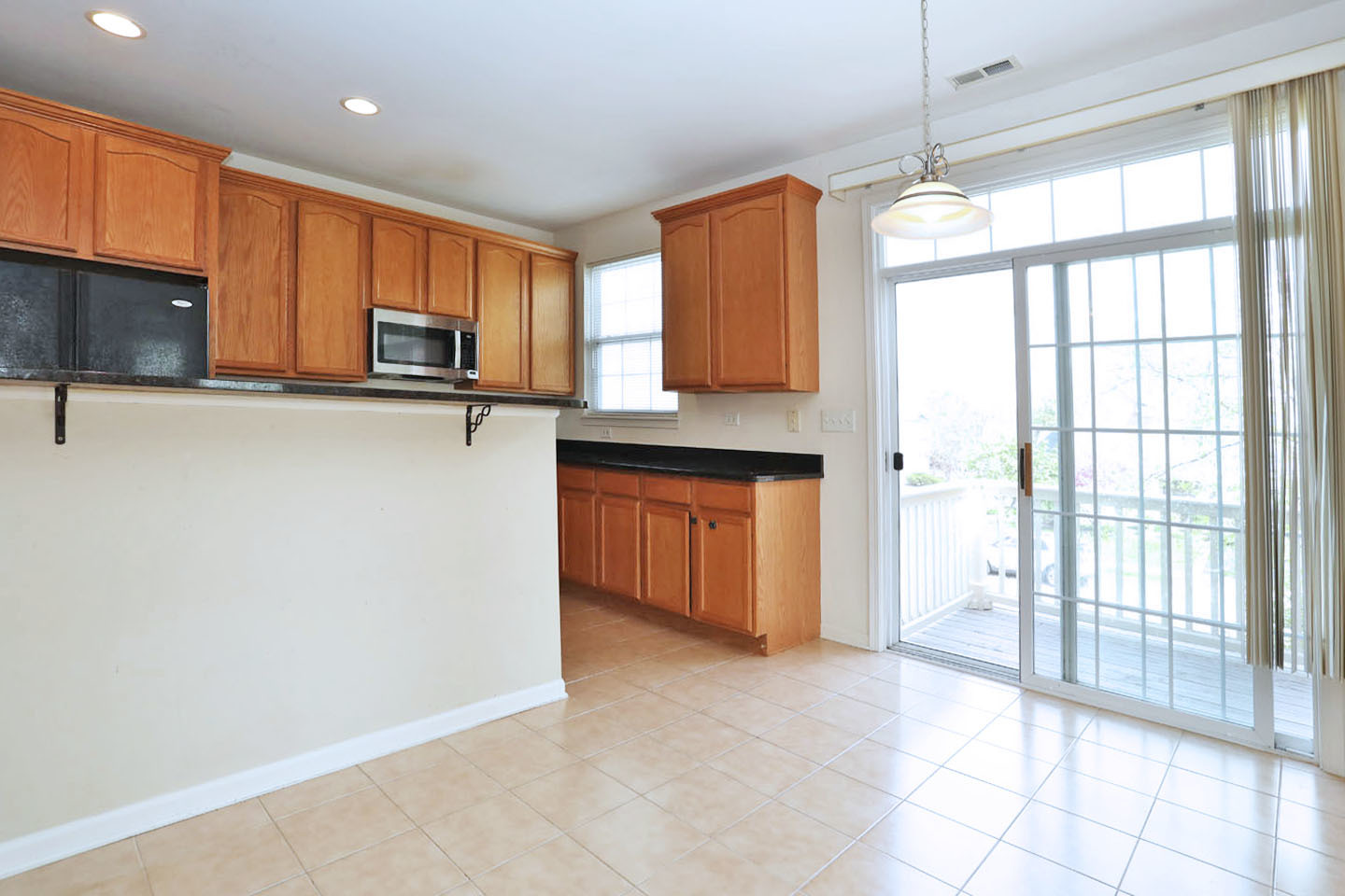 1359 Scarboro Road Schaumburg, IL 60193 - Photo 9 of 21 a kitchen with kitchen island granite countertop a stove a sink and a refrigerator