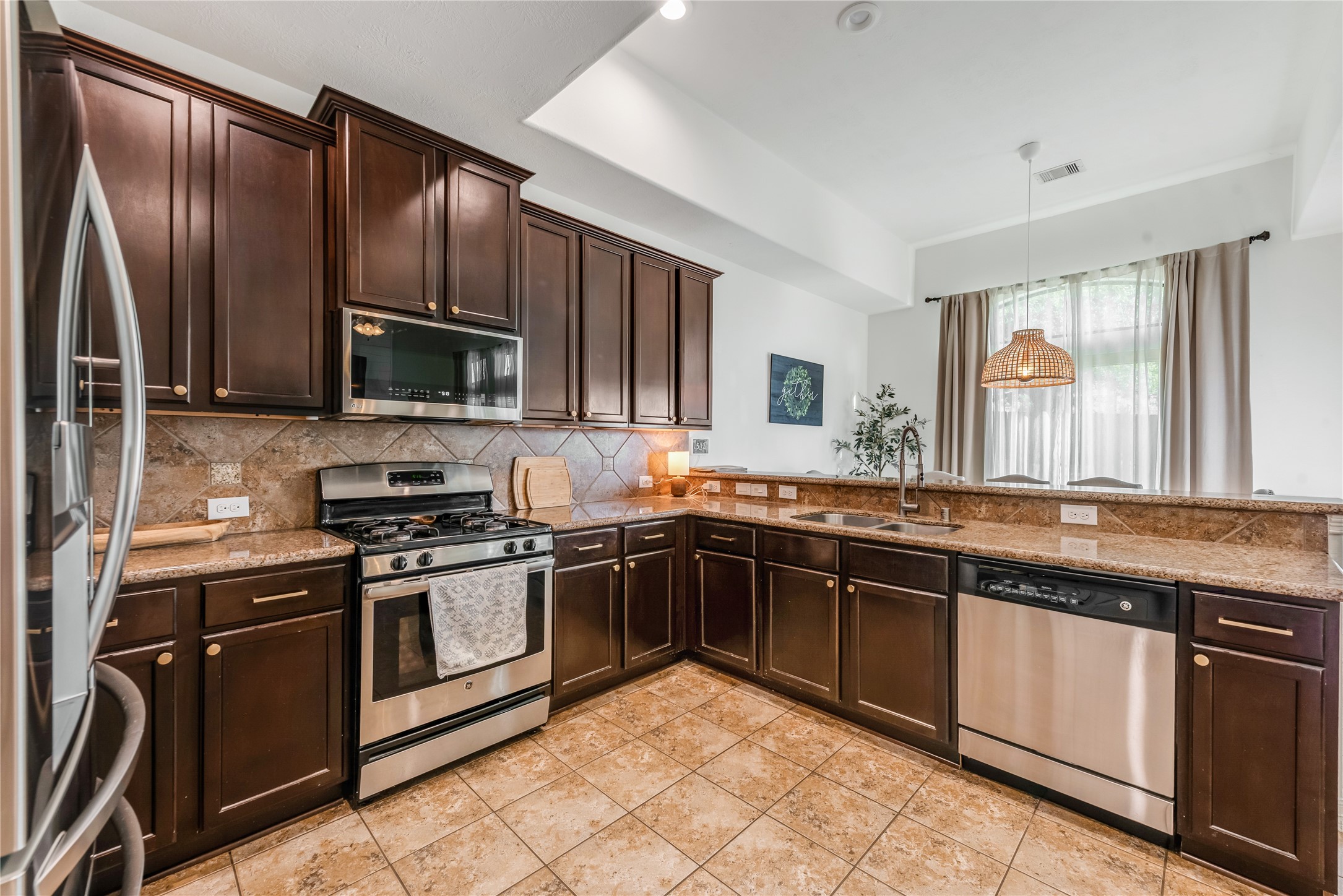 702 Aulia Lane Spring, TX 77386 - Photo 12 of 37 a kitchen with stainless steel appliances granite countertop a stove top oven a sink and dishwasher