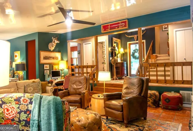 a living room with furniture a fireplace and a floor to ceiling window