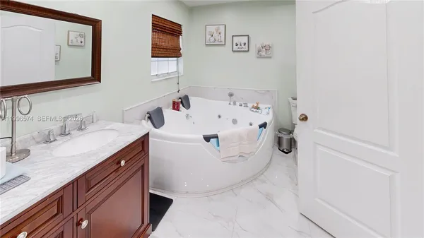 an empty room with wooden floor chandelier fan and windows