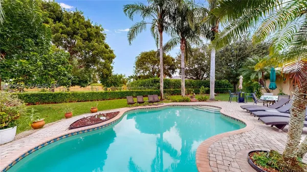 an aerial view of residential houses with outdoor space and trees all around