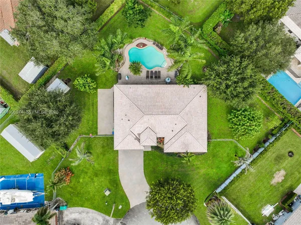 an aerial view of residential houses with outdoor space and trees