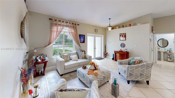 a living room with furniture a flat screen tv and a window