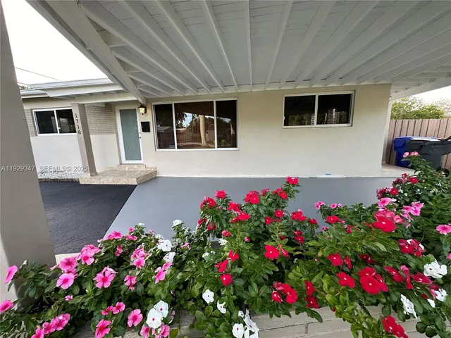 a flower garden in front of a house