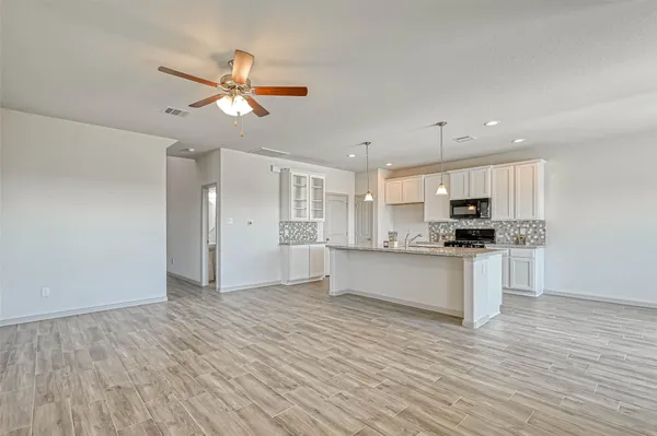 a view of kitchen with refrigerator microwave and stove top oven