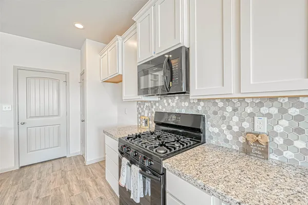a kitchen with granite countertop cabinets stainless steel appliances and a counter space