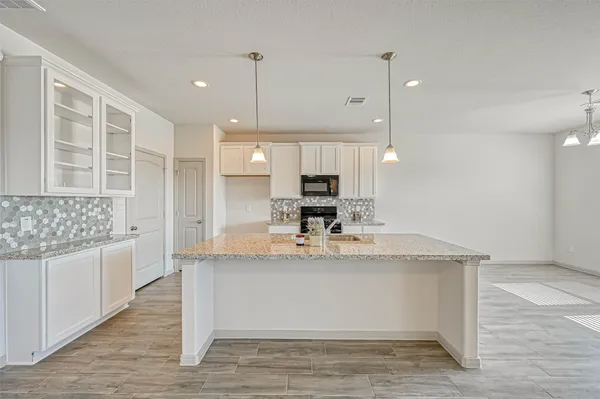 a large kitchen with kitchen island granite countertop a large counter top stainless steel appliances and cabinets