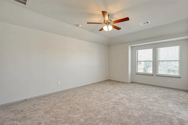 an empty room with closet and a chandelier fan