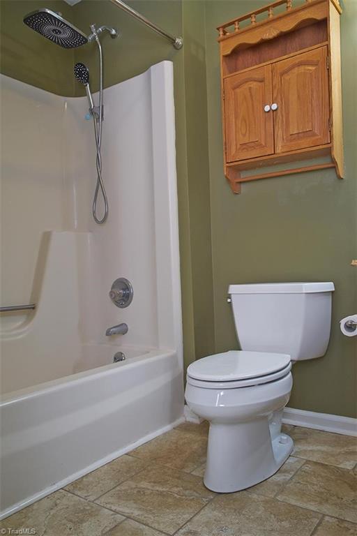 1012 Springwood Lane Archdale, NC 27370 - Photo 27 of 46 Primary bathroom has a Kohler toilet, glazed porcelain tile floors, and a shower rain head.