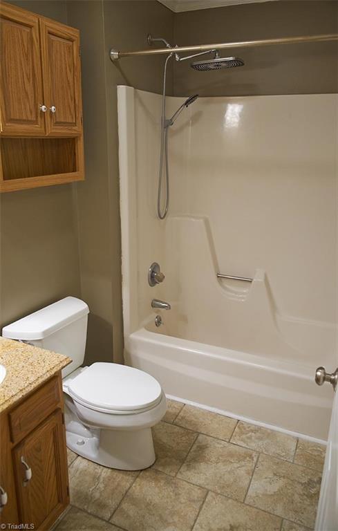 1012 Springwood Lane Archdale, NC 27370 - Photo 34 of 46 Hall bathroom has a tub/shower combo, a Kohler toilet and glazed porcelain tile floors.