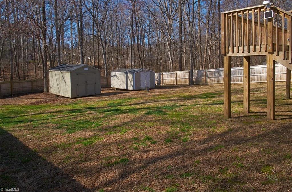 1012 Springwood Lane Archdale, NC 27370 - Photo 38 of 46 Spacious backyard! Privacy fencing installed in 2022. Both storage buildings remain. Motion detector on corner of deck remains.