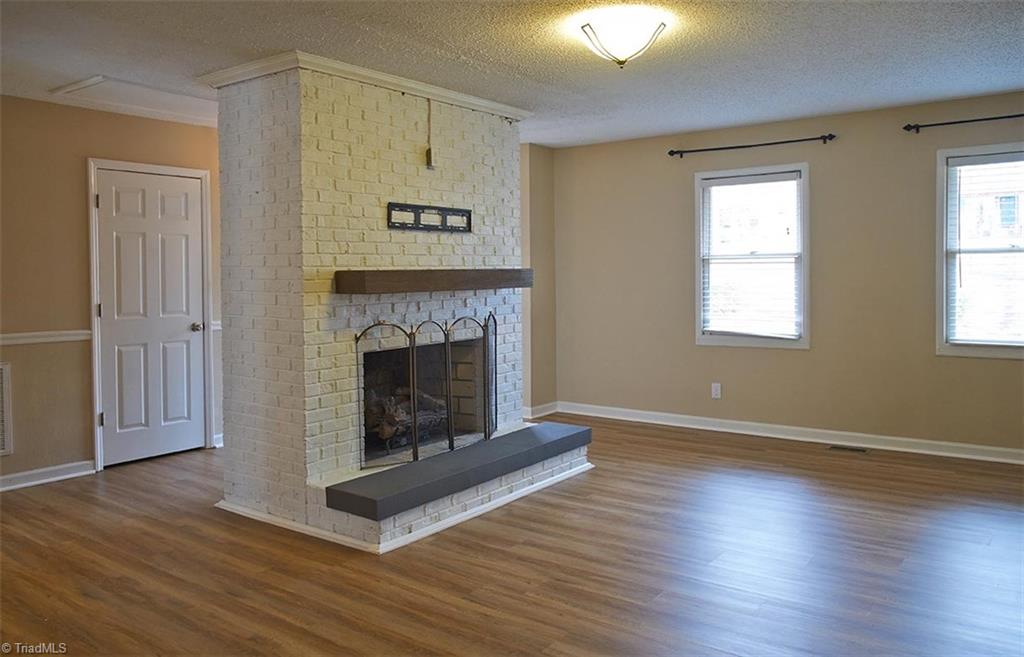 1012 Springwood Lane Archdale, NC 27370 - Photo 9 of 46 Bright and open living room! Beautiful fireplace with gas logs and a foam safety cover over the hearth.