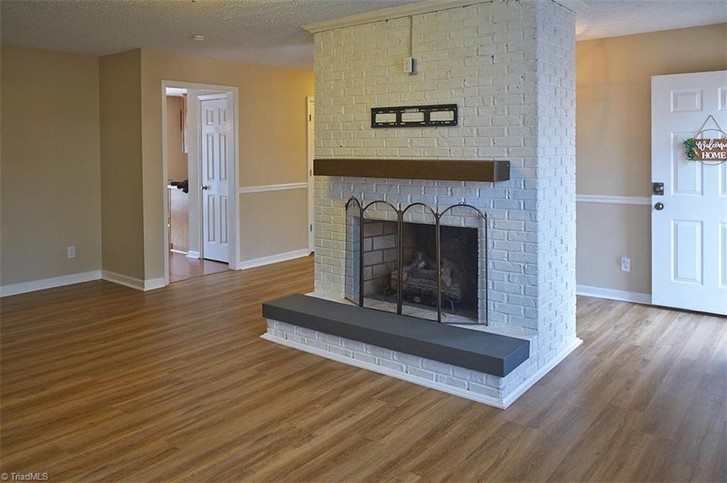 1012 Springwood Lane Archdale, NC 27370 - Photo 10 of 46 So much charm! Fireplace with gas logs and a mantle. Open door on the left leads into the kitchen.