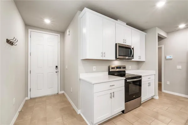 a kitchen with stainless steel appliances granite countertop a sink a stove top oven a counter space and cabinets