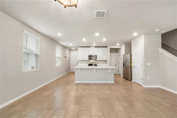 a large kitchen with kitchen island a sink a stove a refrigerator and a cabinets