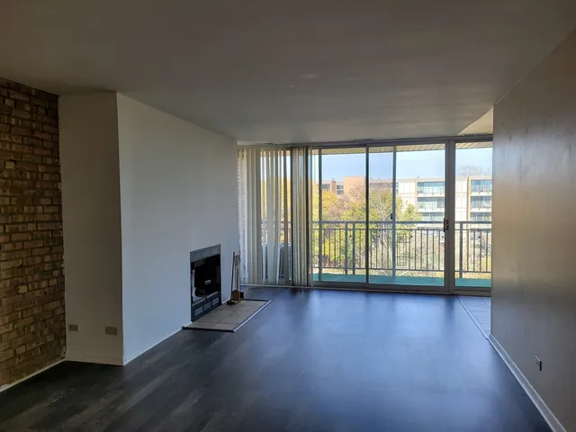 a view of a livingroom with wooden floor and a fireplace