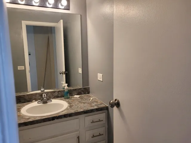 a bathroom with a granite countertop sink and a mirror