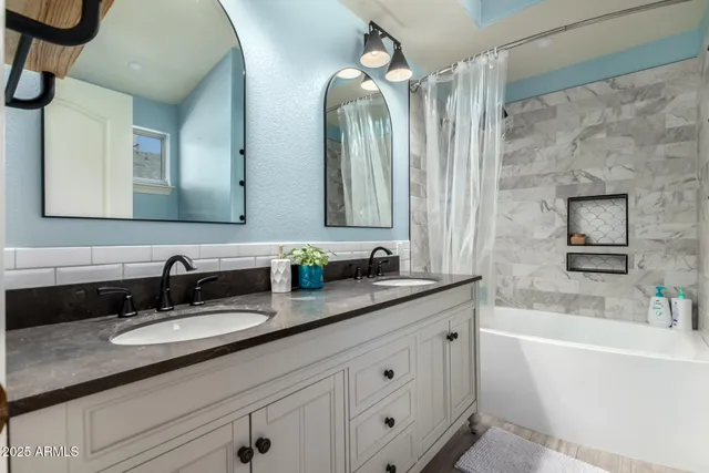 a bathroom with a granite countertop sink mirror and bathtub