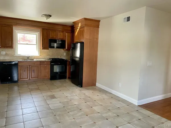 a kitchen with granite countertop a refrigerator and a stove top oven