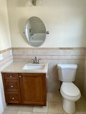 a bathroom with a toilet sink and mirror