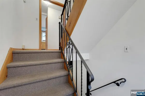 a view of staircase with wooden floor and white walls