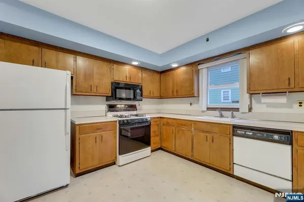 a kitchen with stainless steel appliances granite countertop a refrigerator stove a sink dishwasher and microwave