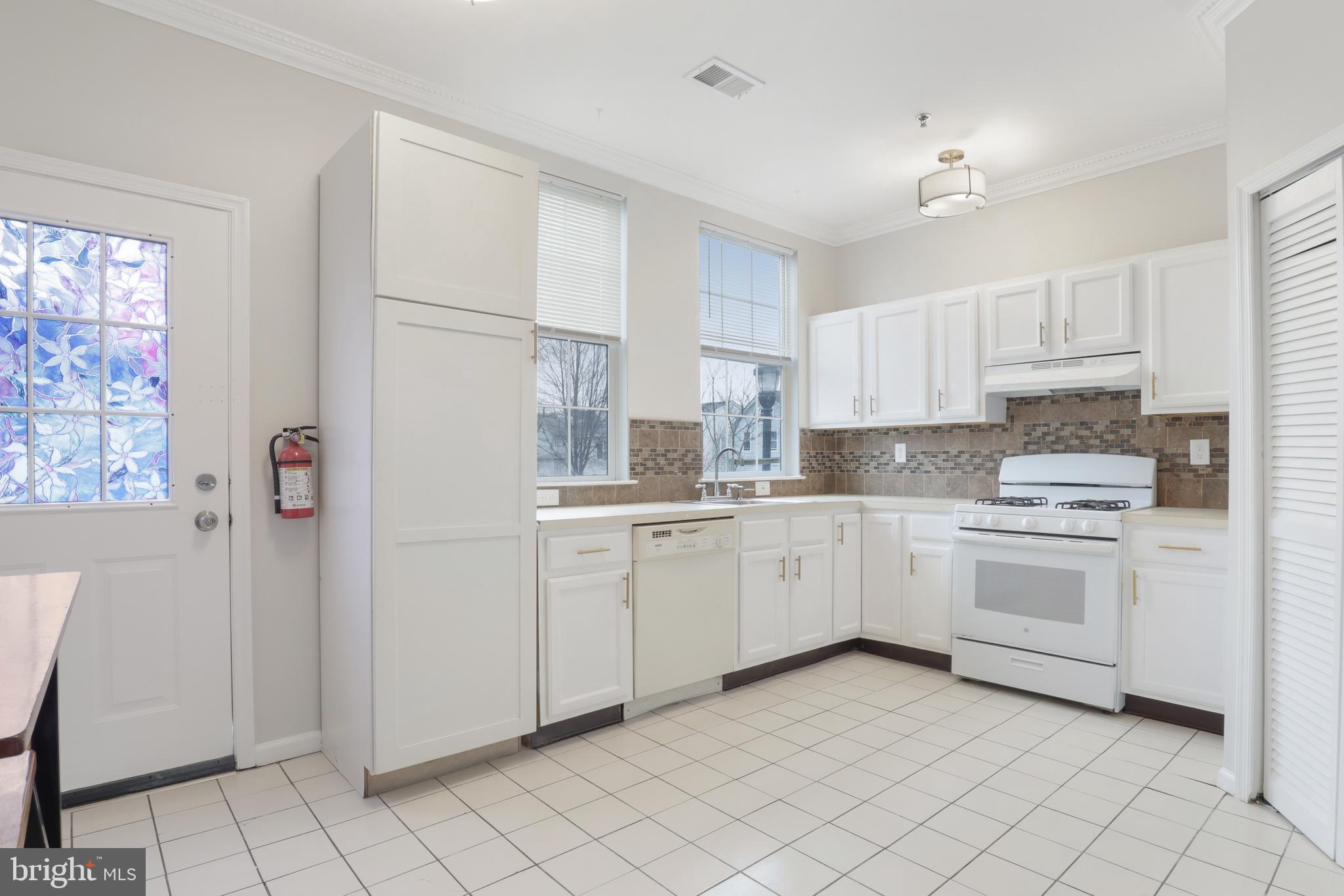 130B Remsen Avenue New Brunswick, NJ 08901 - Photo 9 of 33 a kitchen with white cabinets and white appliances