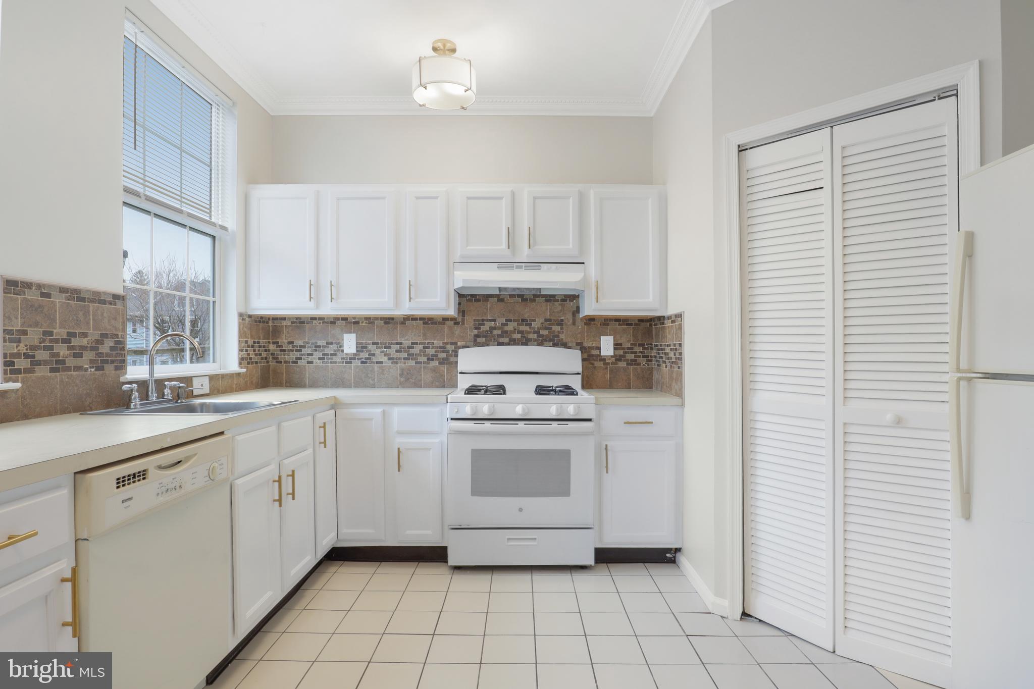 130B Remsen Avenue New Brunswick, NJ 08901 - Photo 10 of 33 a kitchen with white cabinets and white appliances