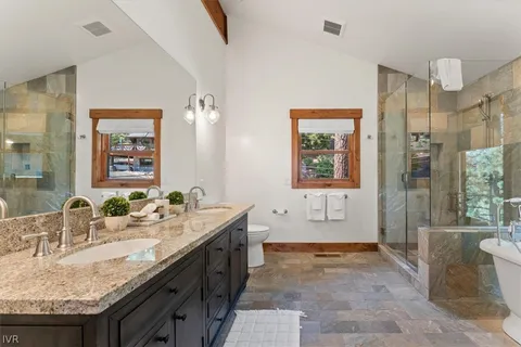 a spacious bathroom with a granite countertop tub sink and mirror