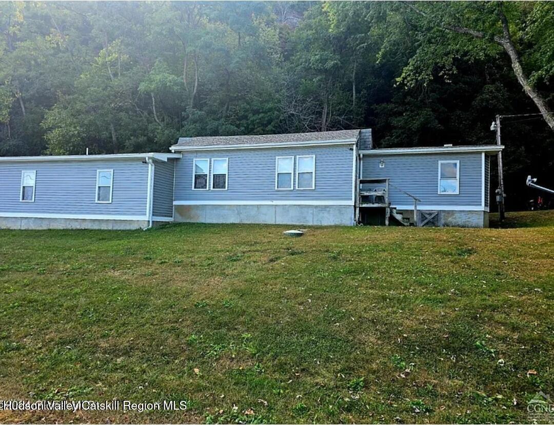 a view of a yard in front of a house with large tree