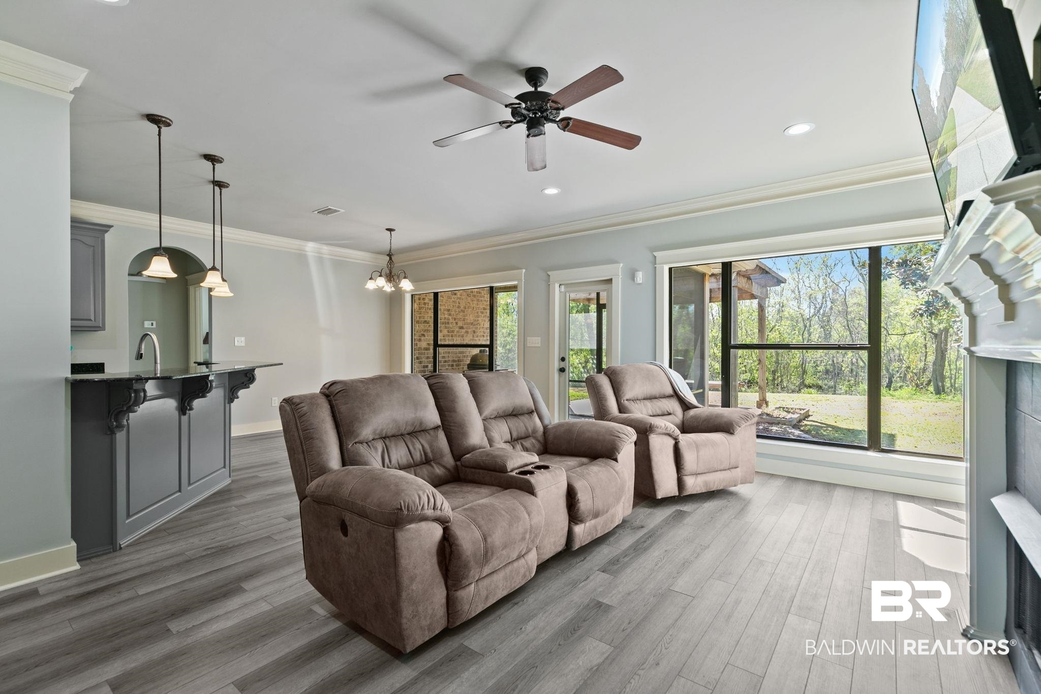 9584 Sanibel Loop Daphne, AL 36526 - Photo 12 of 48 Living area with ornamental molding, light wood-type flooring, a chandelier, and ceiling fan