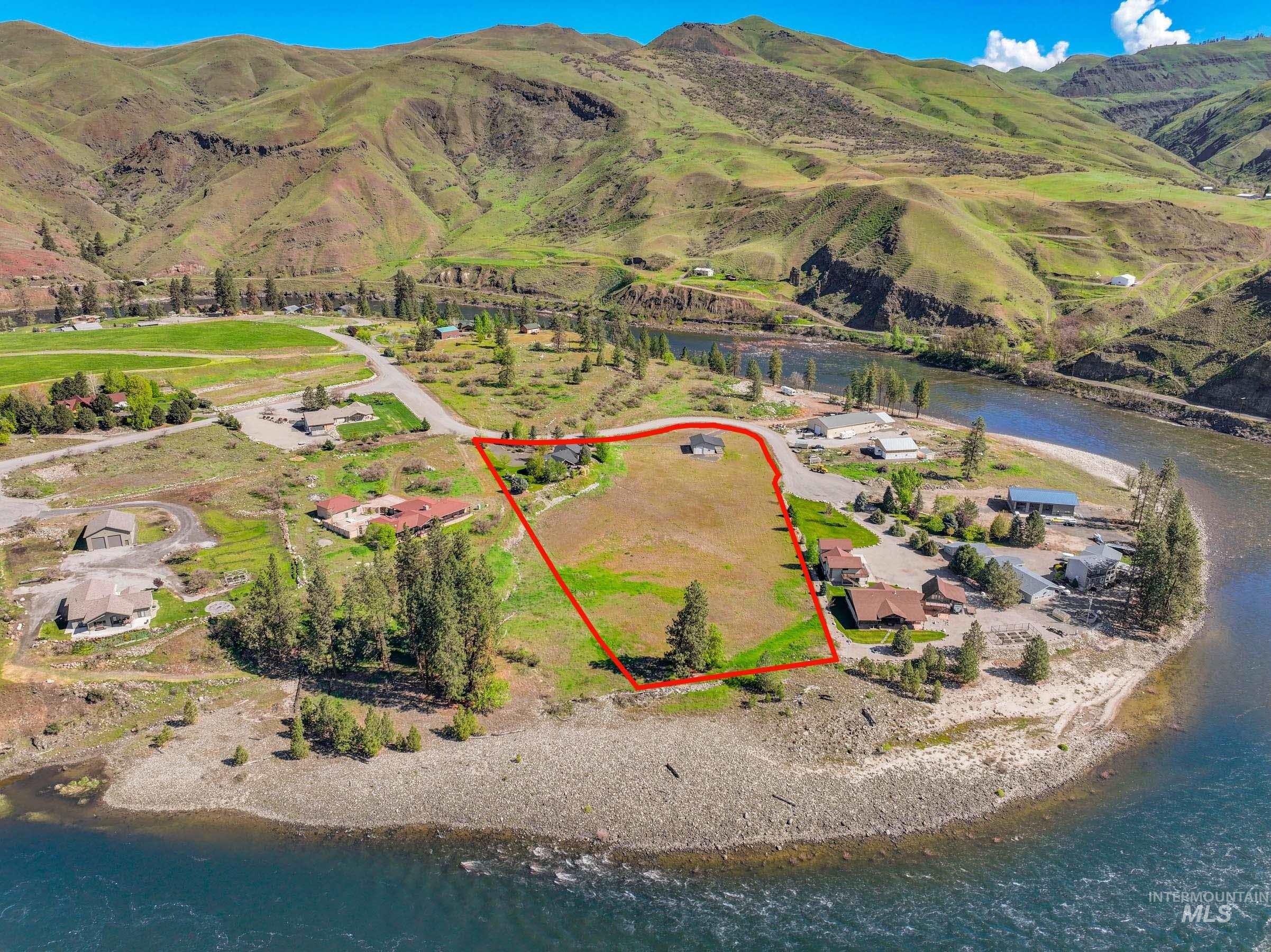 113 Deford Road White Bird, ID 83554 - Photo 48 of 49 Expansive riverfront property featuring a prominent river bend, mountainous backdrop, and established roadway access