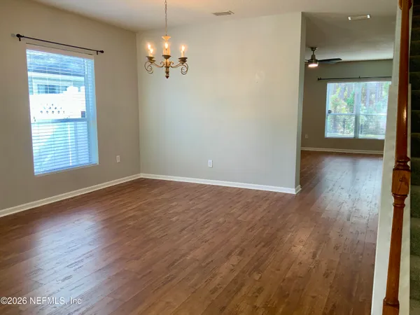 a view of a hallway with wooden floor and stairs
