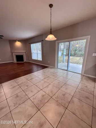 a view of an empty room with wooden floor and a ceiling fan