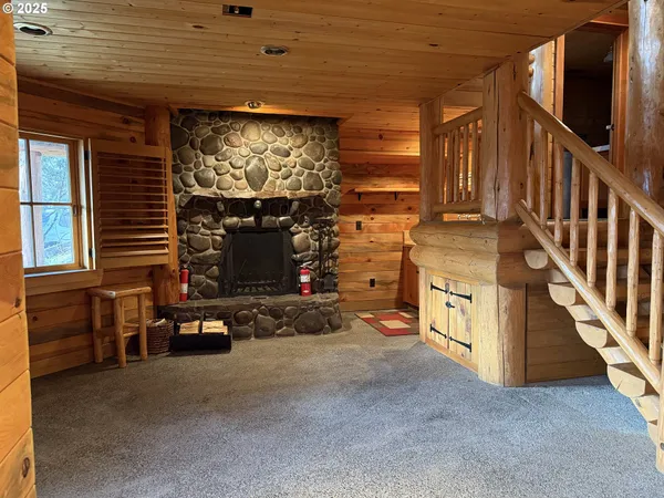 a view of an empty room with wooden floor and windows
