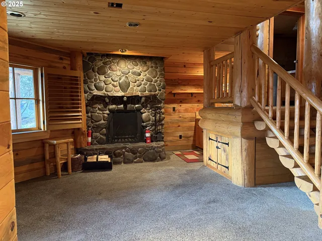 a view of an empty room with wooden floor and windows