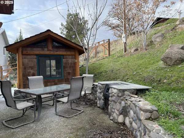a view of a chairs and table in backyard of the house