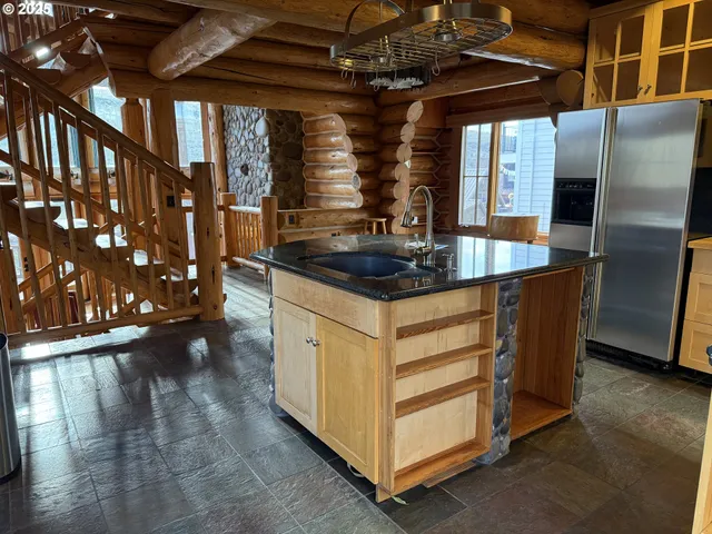 a kitchen with stainless steel appliances granite countertop a sink a stove and a refrigerator