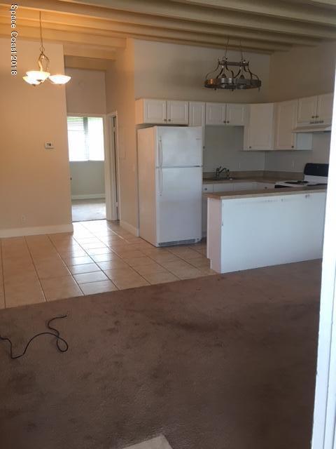 1708 Elm Street, Unit 8 Rockledge, FL 32955 - Photo 3 of 9 a view of a refrigerator in kitchen and an empty room