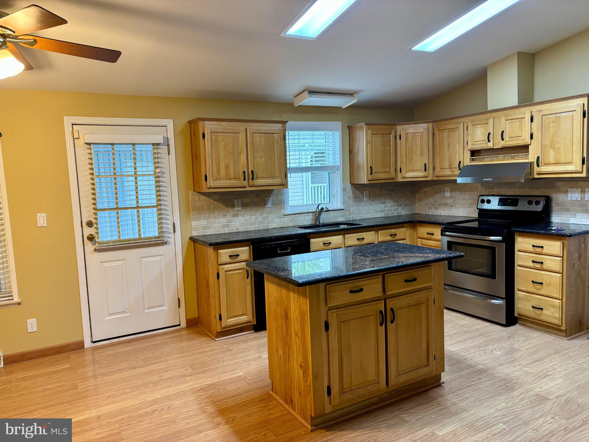 399 Spring Meadow Circle New Hope, PA 18938 - Photo 11 of 37 a kitchen with stainless steel appliances granite countertop a stove a sink dishwasher and a refrigerator with wooden floor