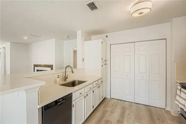 a kitchen with white cabinets and sink