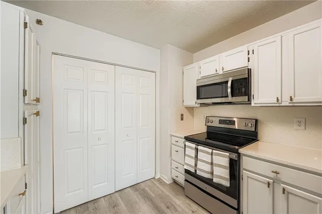 a kitchen with white cabinets stainless steel appliances and sink