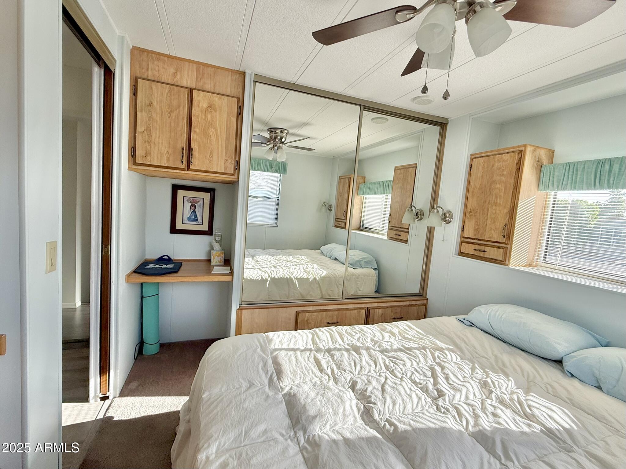 8865 East Baseline Road, Unit 1643 Mesa, AZ 85209 - Photo 14 of 44 a bedroom with a large bed and a chandelier