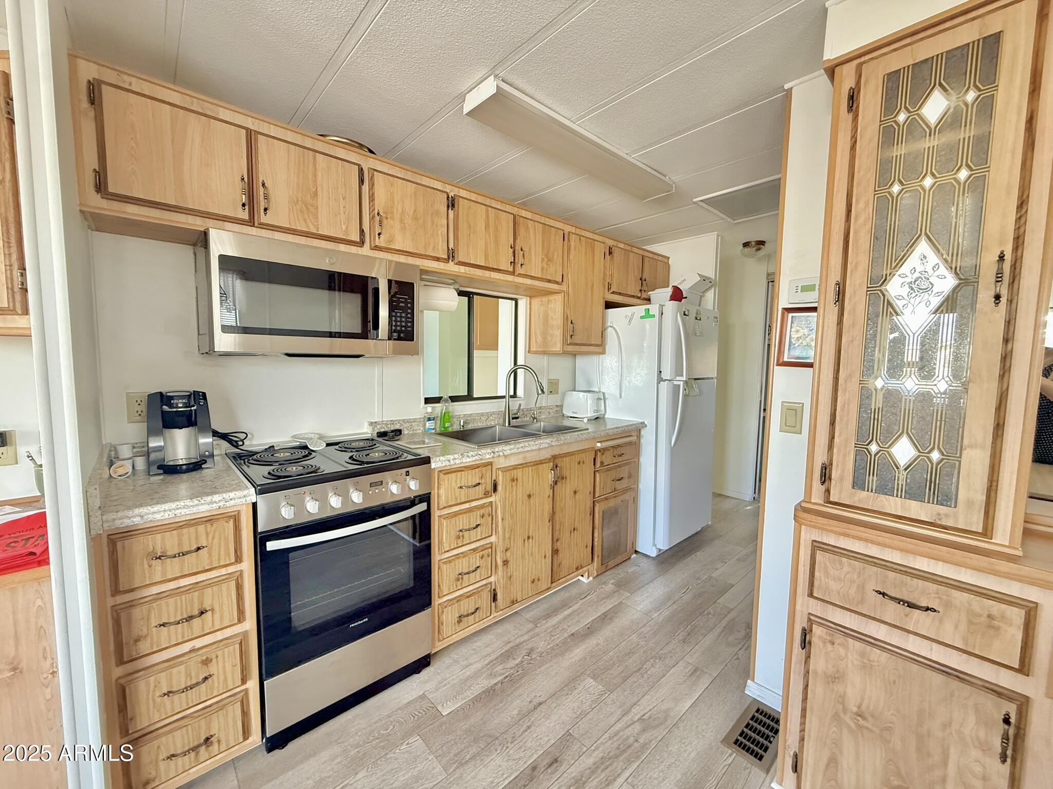 8865 East Baseline Road, Unit 1643 Mesa, AZ 85209 - Photo 3 of 44 a kitchen with stainless steel appliances granite countertop a stove a sink and a refrigerator